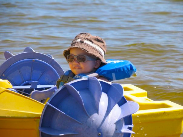 Young child riding on a paddle boat